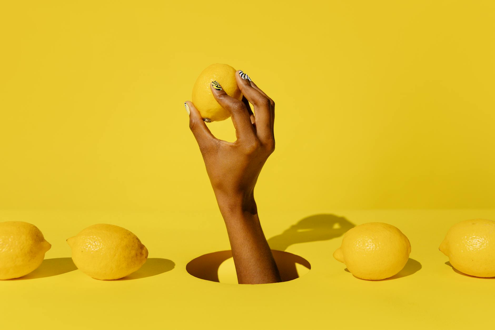 Fresh yellow lemon held against a bright background, representing the refreshing transition to new sensation with lemon vibrators