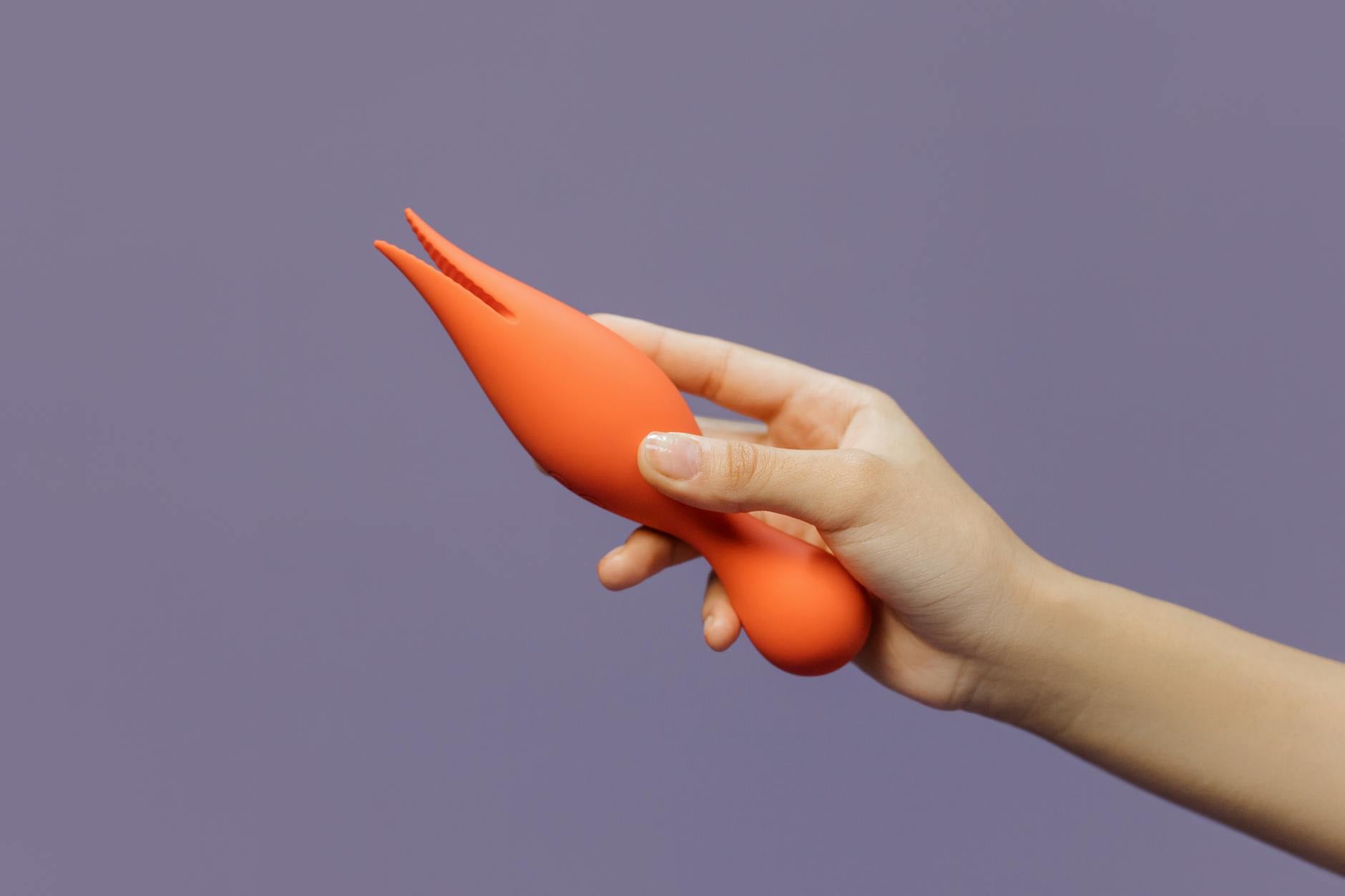 Close-up of hands holding a vibrator together, showcasing partnership and intimacy