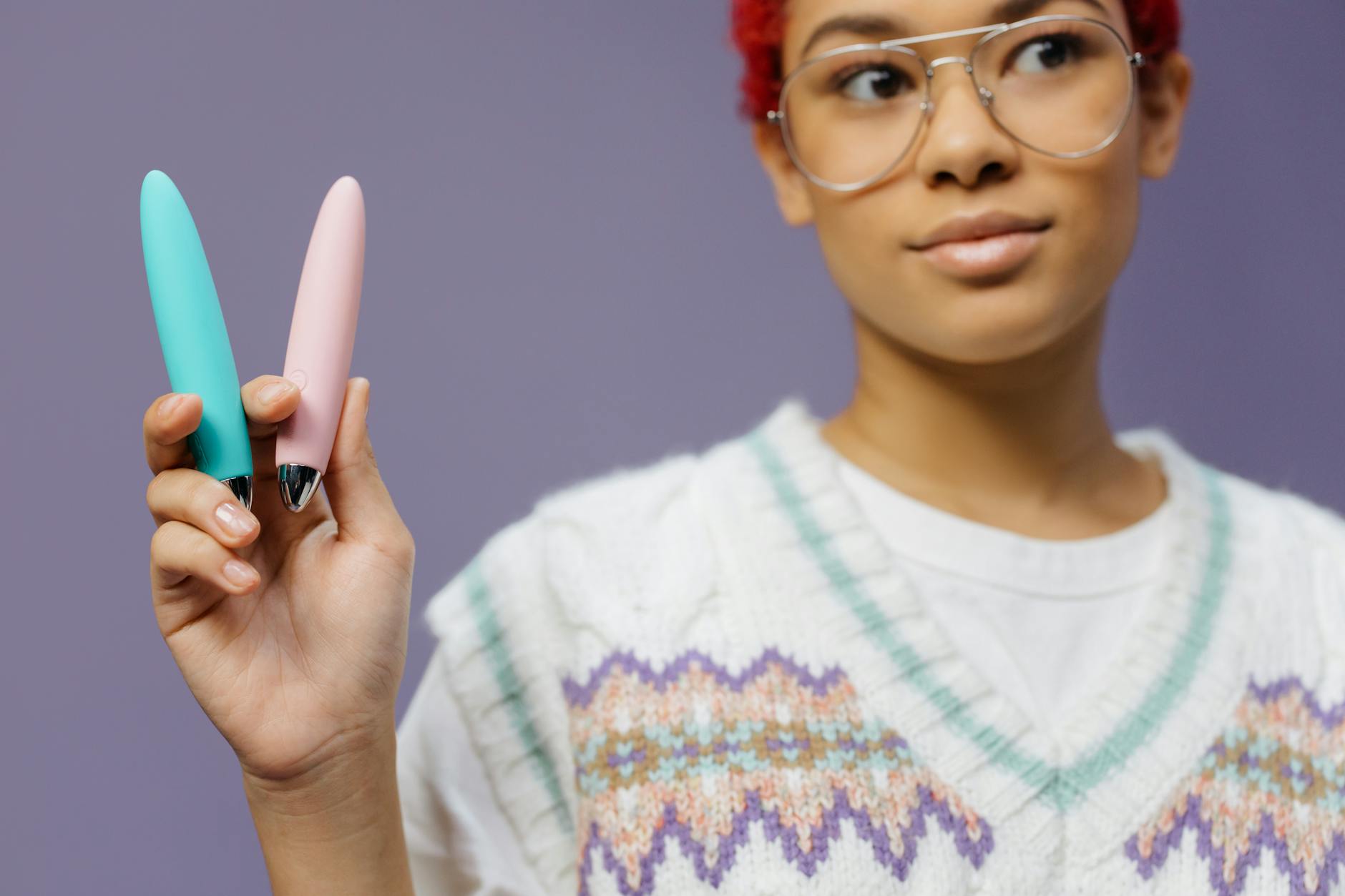 Colorful vibrators displayed on a purple background, representing pleasure device options